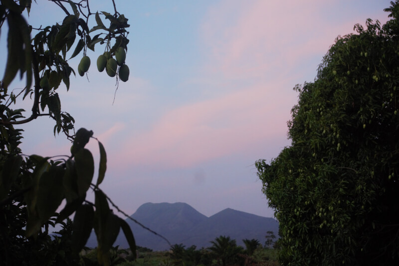 Vue sur le Mont Mbappit au Cameroun, nuages roses à la tombée de la nuit.